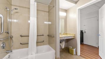 A bathroom with a bathtub, a shower, and a sink with a mirror.