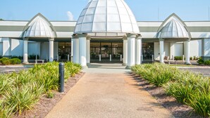 Um edifício com uma cúpula central e duas cúpulas menores de cada lado, ladeado por colunas.
