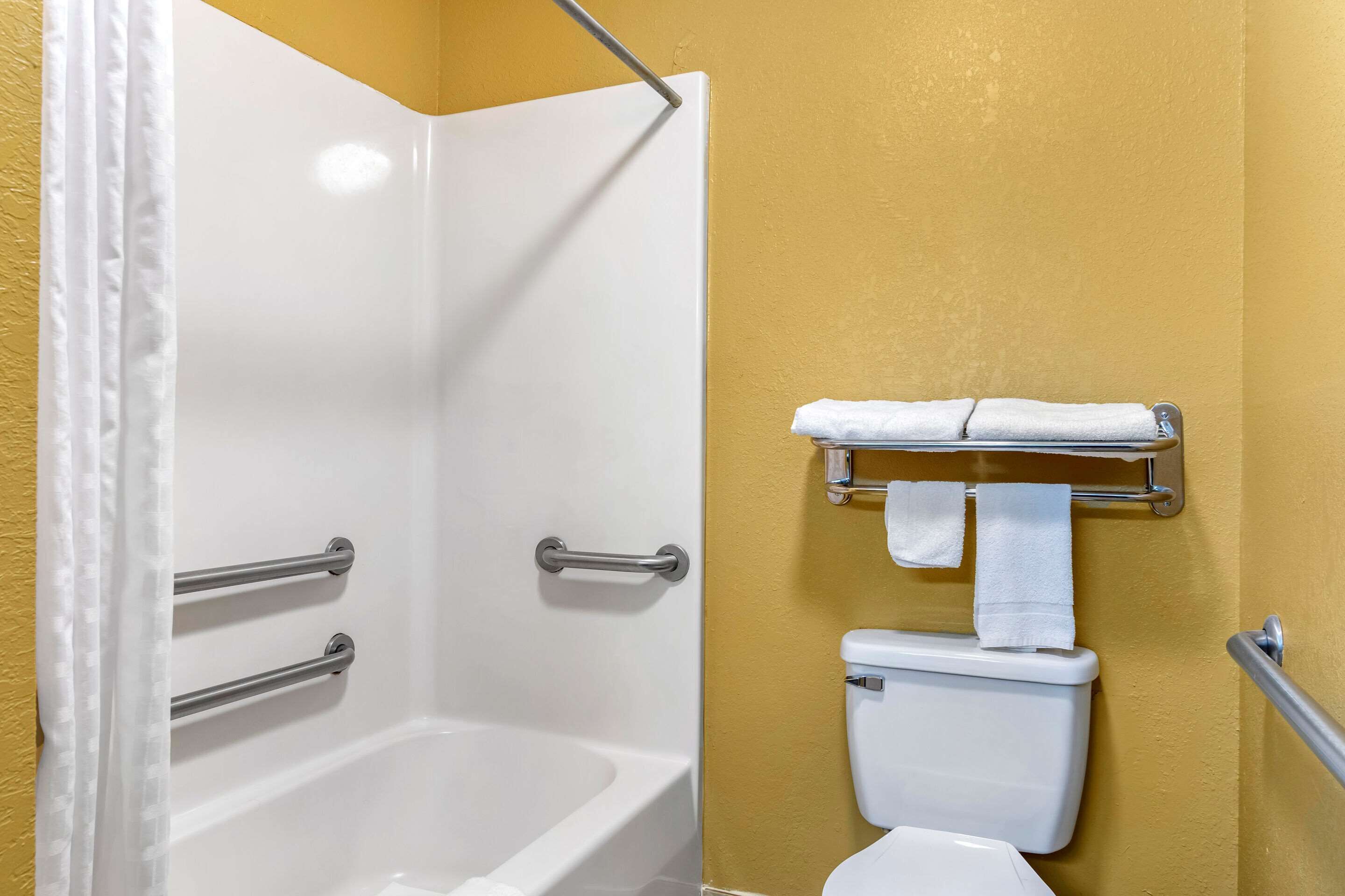 Une salle de bain équipée d’une baignoire, de toilettes et d’un porte-serviettes.