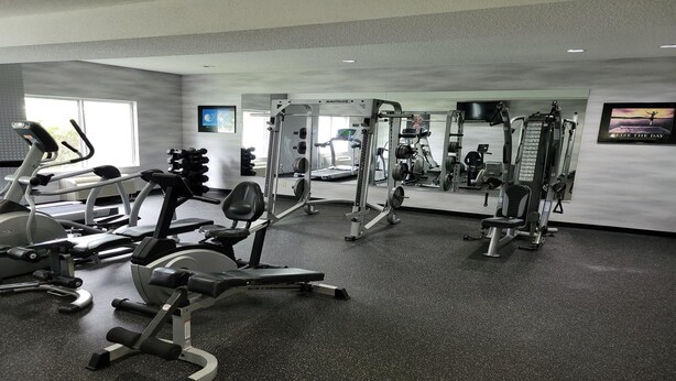A gym with cardio machines, weightlifting equipment, and a mirror. - City Express By Marriott Shepherdsville Louisville (Louisville)