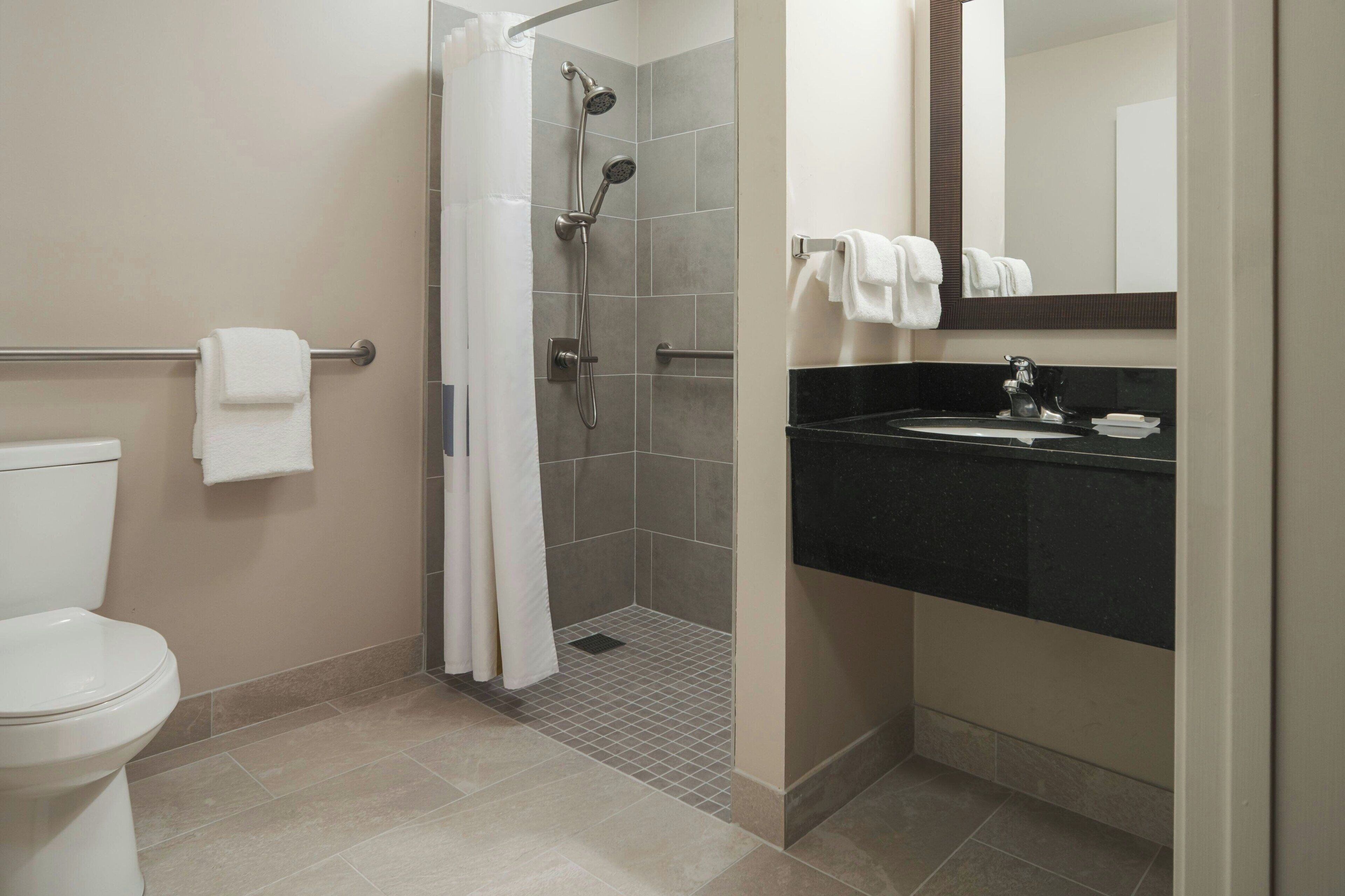A bathroom with a shower, toilet, and sink.