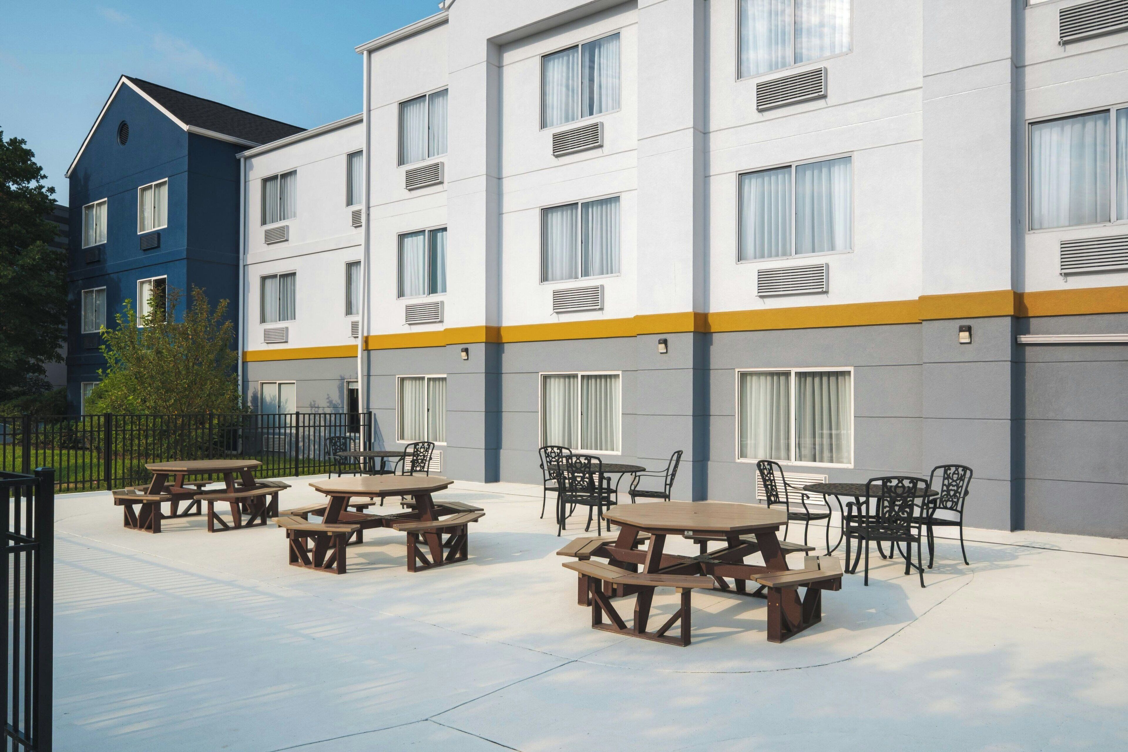 Un immeuble à plusieurs étages doté d’espaces extérieurs aménagés en terrasses et d’une façade bleue et blanche.