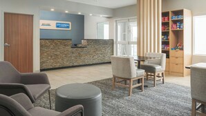 A reception area with a stone wall, a blue sign, and a snack shelf.