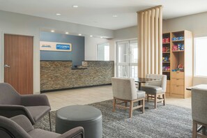 A reception area with a stone wall, a blue sign, and a snack shelf. - City Express By Marriott Shepherdsville Louisville (Louisville)
