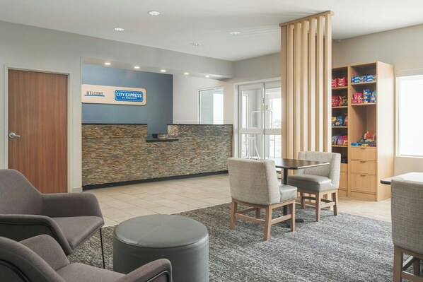 A reception area with a stone wall, a blue sign, and a snack shelf.