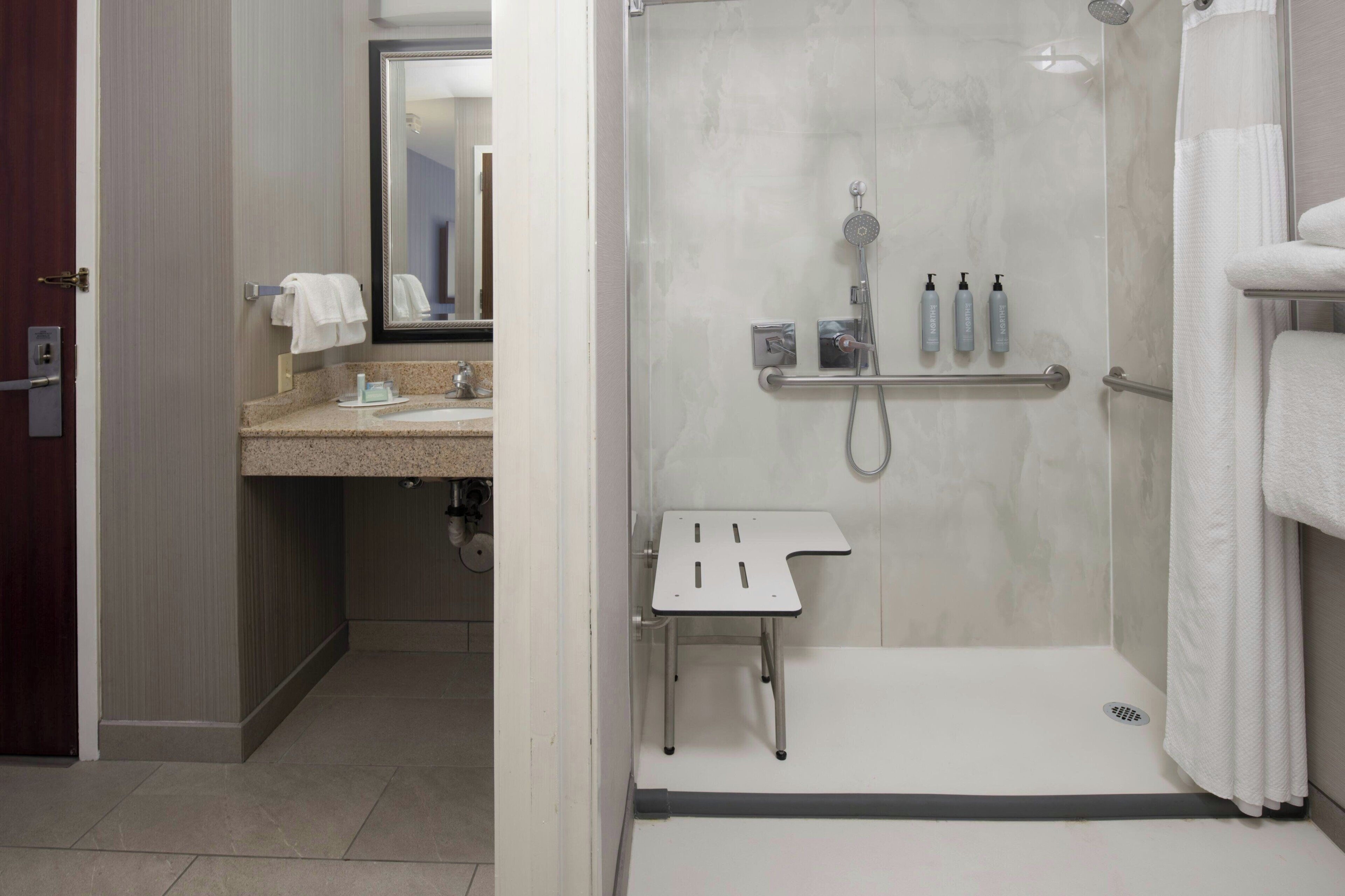 Ein modernes Badezimmer mit Dusche, Waschbecken und Spiegel.