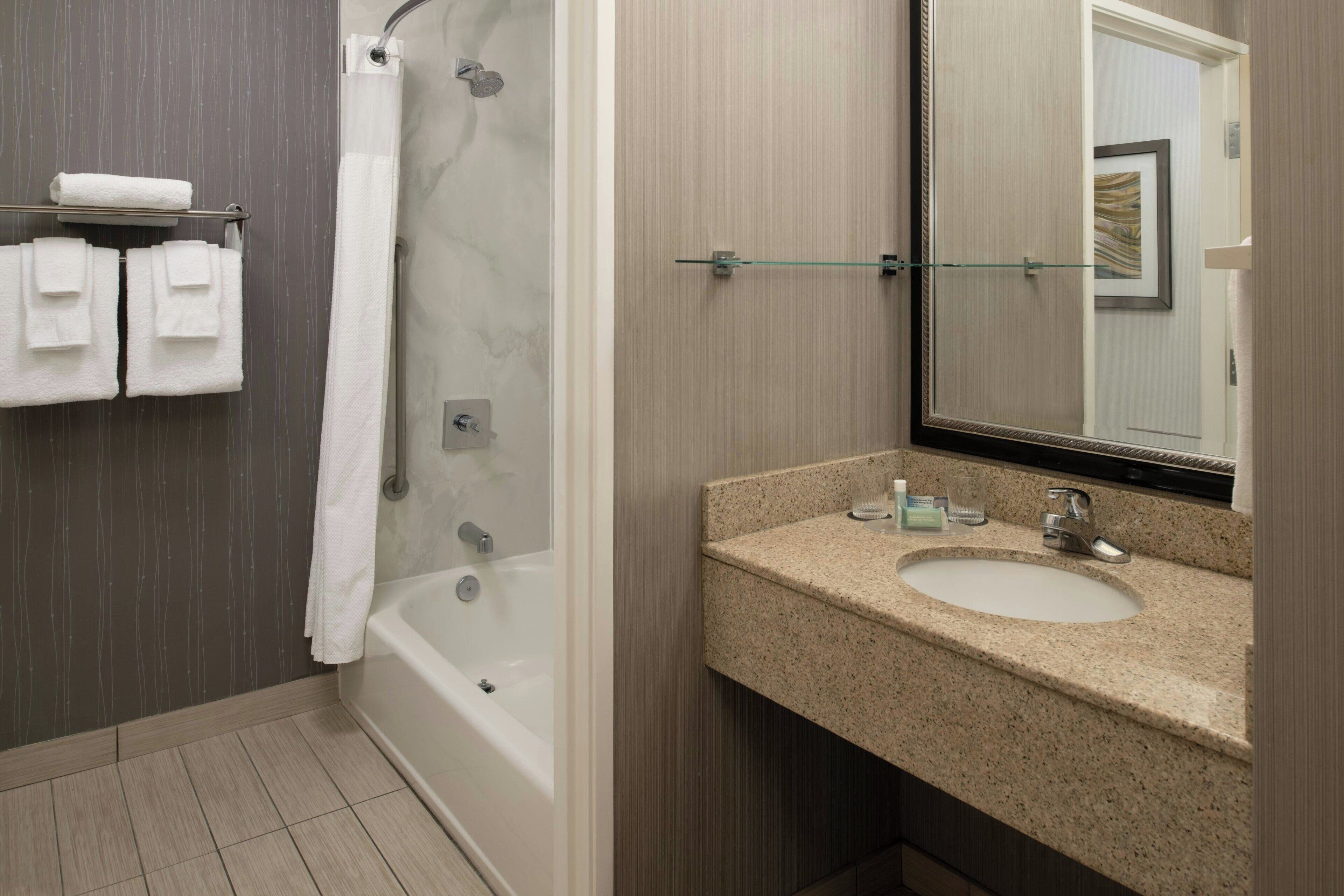 combined shower/bathtub, designer toiletries, hair dryer, towels