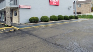 A Red Roof Inn with a registration sign, a balcony, and a parking lot.