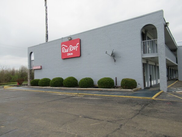 Ein Red Roof Inn mit einer Rezeption, einer Satellitenschüssel und einem Parkplatz.