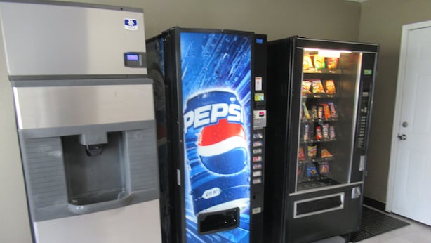 A vending machine with a Pepsi logo, a water dispenser, and a refrigerator.