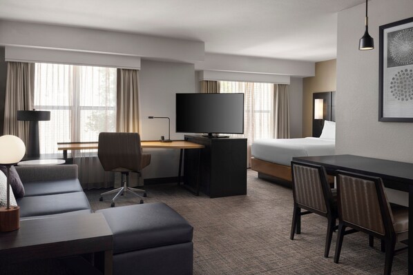 A hotel room with a bed, a desk with a computer, a television, a sofa, and a dining table with chairs. - Residence Inn By Marriott Stockton (Stockton)