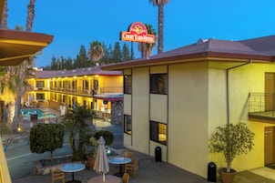 Un hotel con piscina, asientos al aire libre y un cartel que dice "Studio City Court Yard Hotel".