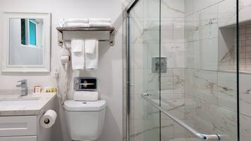 Une salle de bain moderne avec des toilettes, une douche à parois de verre et un mur recouvert de carreaux de marbre.
