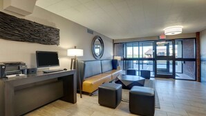 A modern lobby with a reception desk, seating area, and large windows. - Drury Inn Paducah (Paducah)