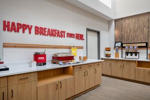 A modern breakfast area with a sign reading 'HAPPY BREAKFAST STARTS HERE.' - Hampton Inn Cartersville (Cartersville)