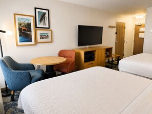 A hotel room with two beds, a TV, a desk with a chair, and framed pictures on the wall. - Hampton Inn Cartersville (Cartersville)