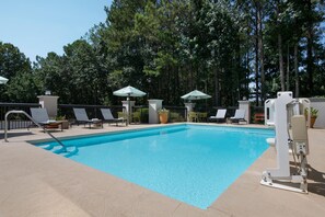 A swimming pool with lounge chairs and umbrellas, surrounded by trees. - Hampton Inn Cartersville (Cartersville)