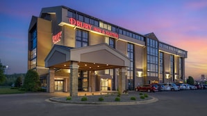 A Drury Inn & Suites building with a modern architectural design, featuring large windows and a well-lit entrance.
