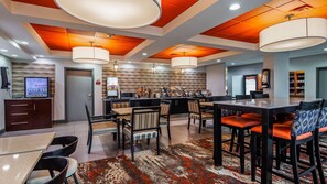 A hotel lobby with a bar area, seating arrangements, and a vending machine. - Comfort Inn & Suites Carrollton (Carrollton)