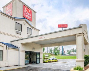 Un Econo Lodge de dues plantes amb entrada coberta i un senyal clar que indica una alçada de 3 metres.