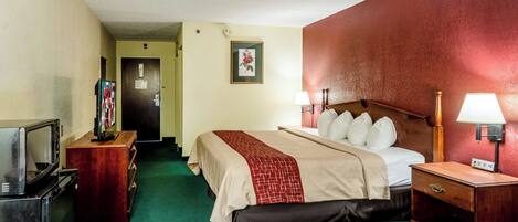A hotel room with a bed, bedside lamps, a television, and a dresser.
