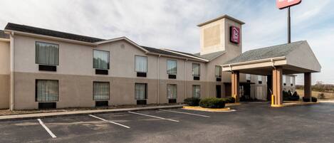 A Red Roof Inn with a covered entrance, multiple windows, and a parking lot.