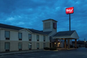 Un hotel Red Roof Inn con un edificio de dos pisos, un acceso cubierto y un estacionamiento.