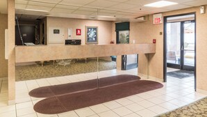 A reception area with a counter, a framed picture, and an exit sign. - Red Roof Inn Morehead (Morehead)