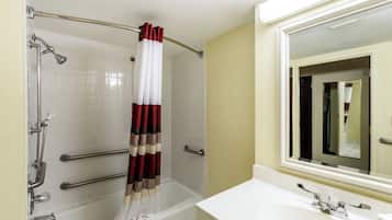 Un baño con bañera, ducha, lavamanos y espejo.