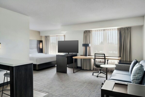 A hotel room with a bed, desk, TV, sofa, and a small table. - Residence Inn By Marriott Merrillville (Merrillville)
