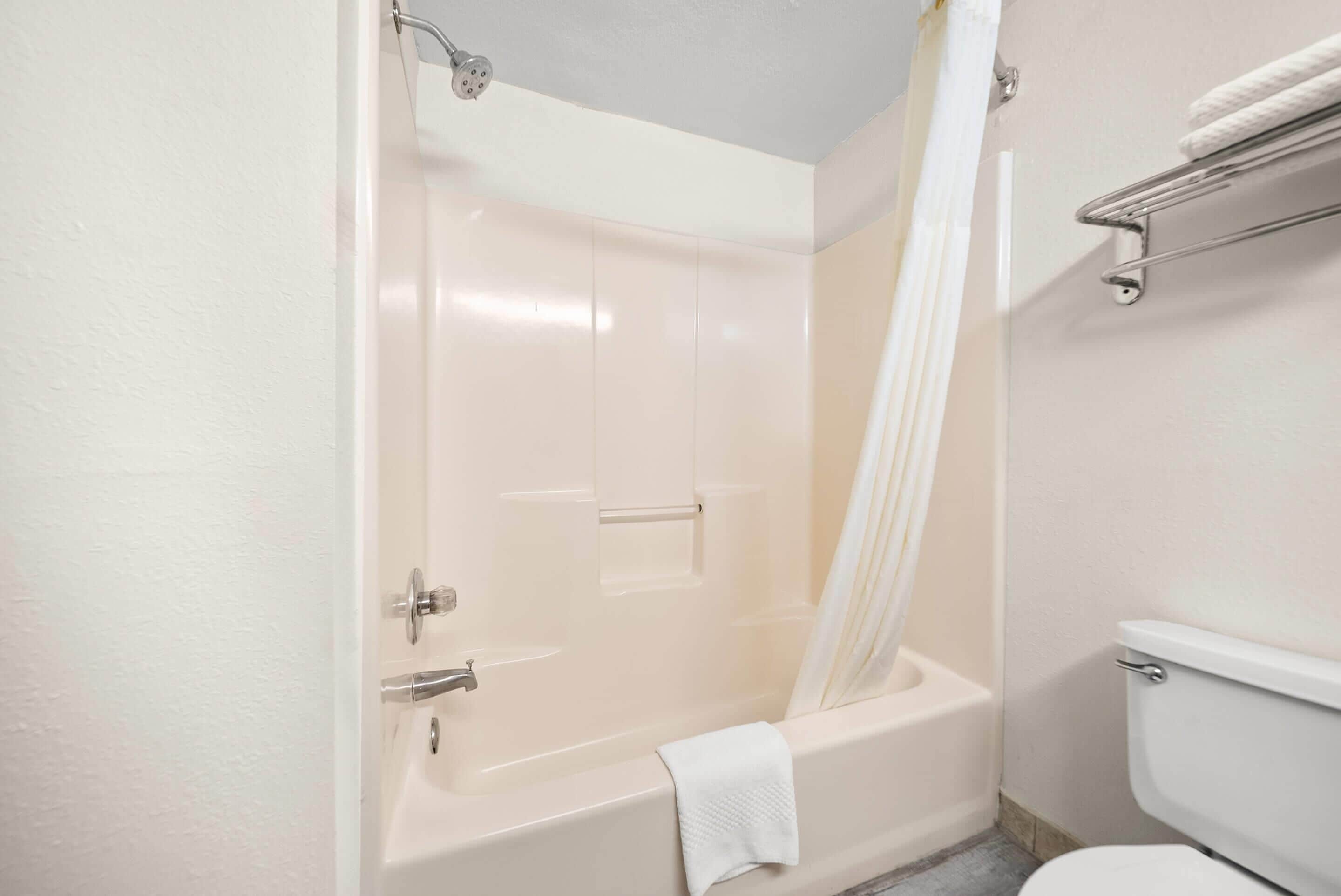Un baño con bañera, inodoro y cortina de ducha.