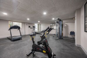A gym with cardio machines, weightlifting equipment, and a mirrored wall. - Days Inn & Suites by Wyndham Lexington (Lexington)