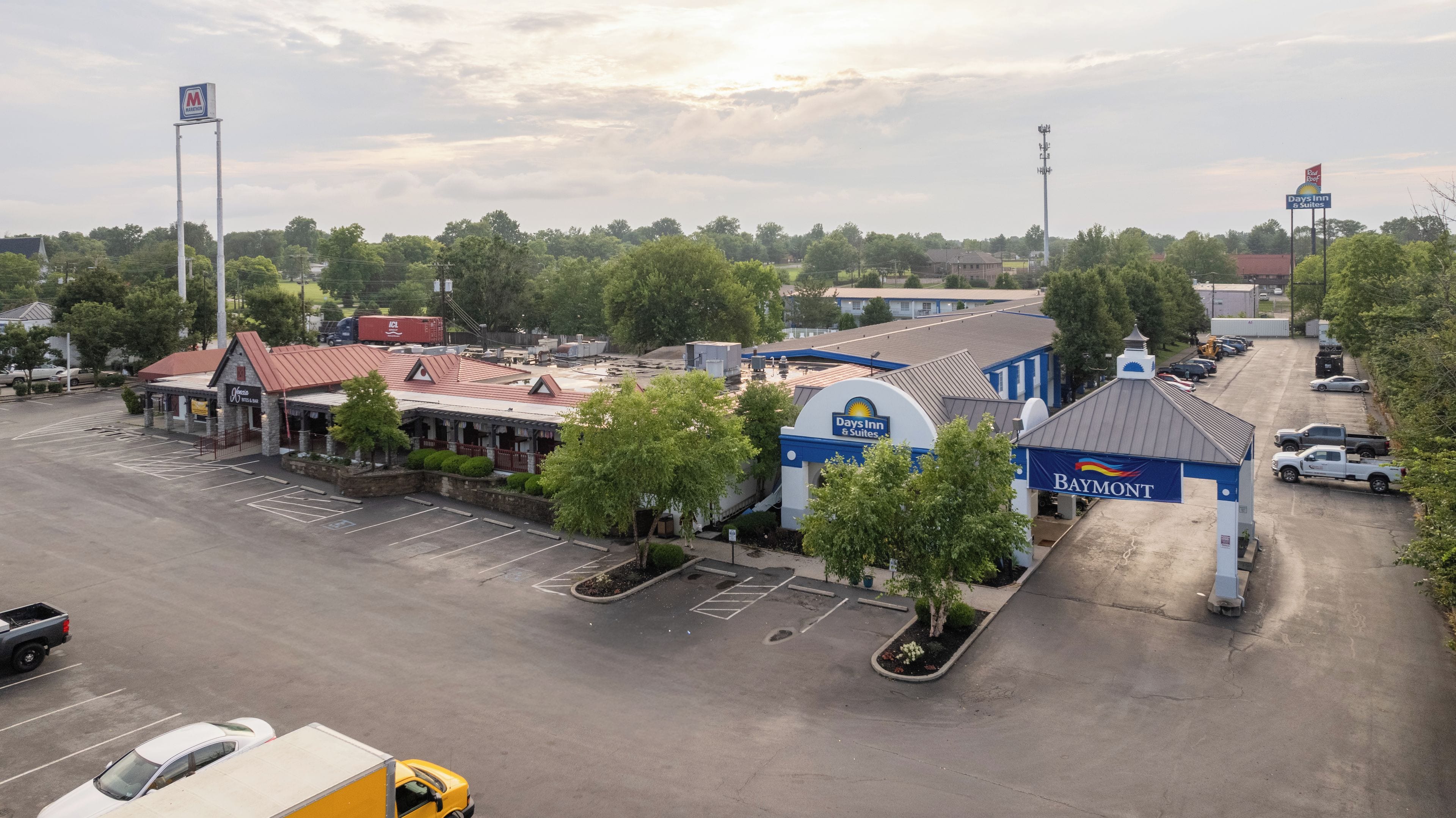 A hotel with a parking lot, a Days Inn sign, and a Baymont sign.