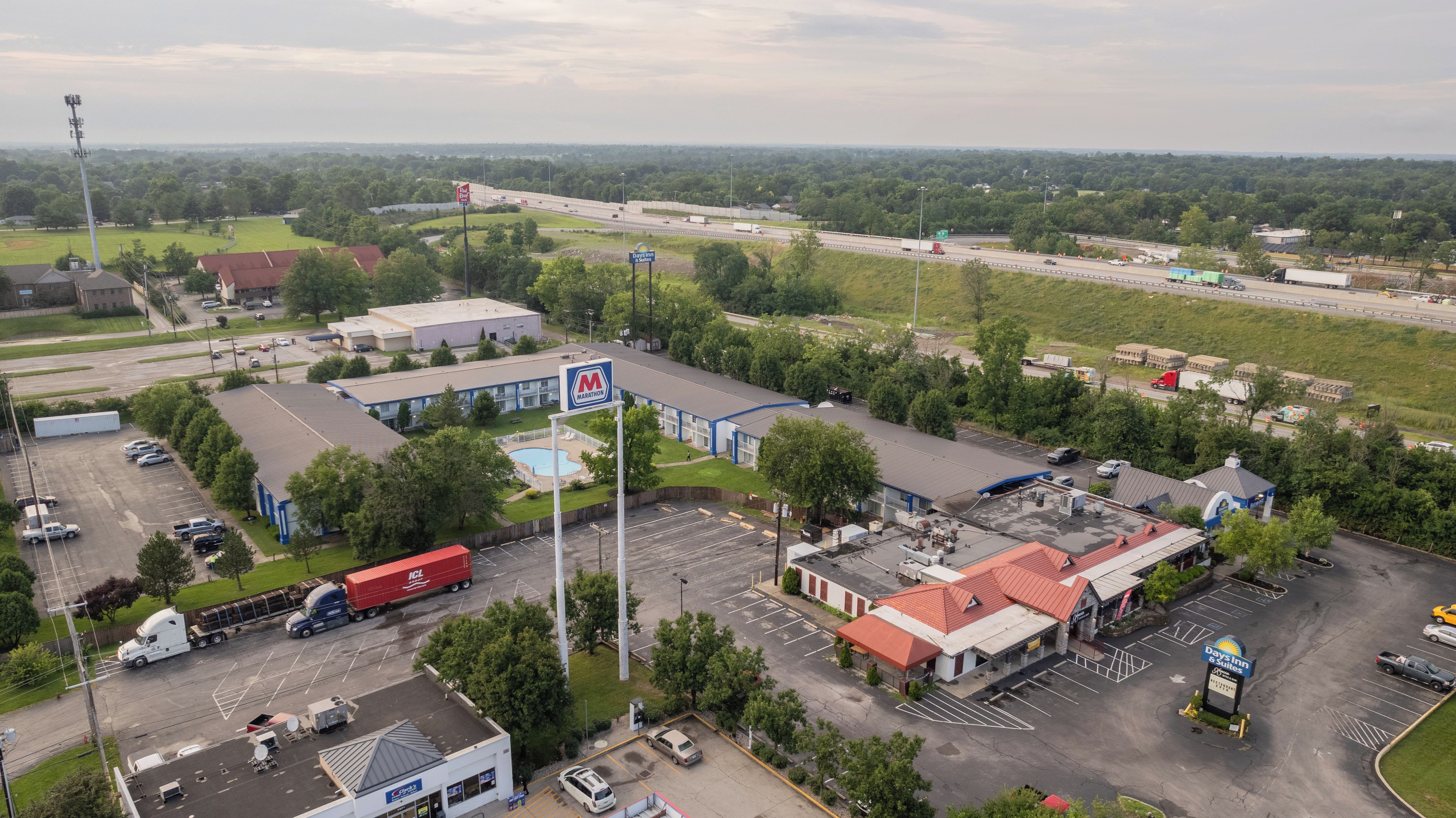 A commercial area with a motel, a swimming pool, and a large parking lot.