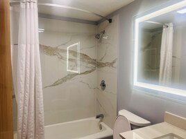 Un baño con ducha, inodoro y lavamanos.