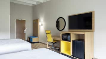 A hotel room with two beds, a desk, a chair, a television, and a microwave.