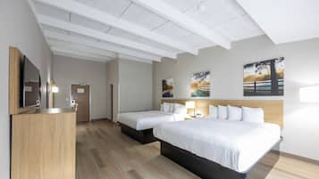 A hotel room with a bed, bedside tables, a desk, and a mirror.