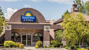 Days Inn & Suites -hotellin rakennus, jossa on selkeästi näkyvä kyltti, suuri kaareva sisäänkäynti ja pysäköintialue.
