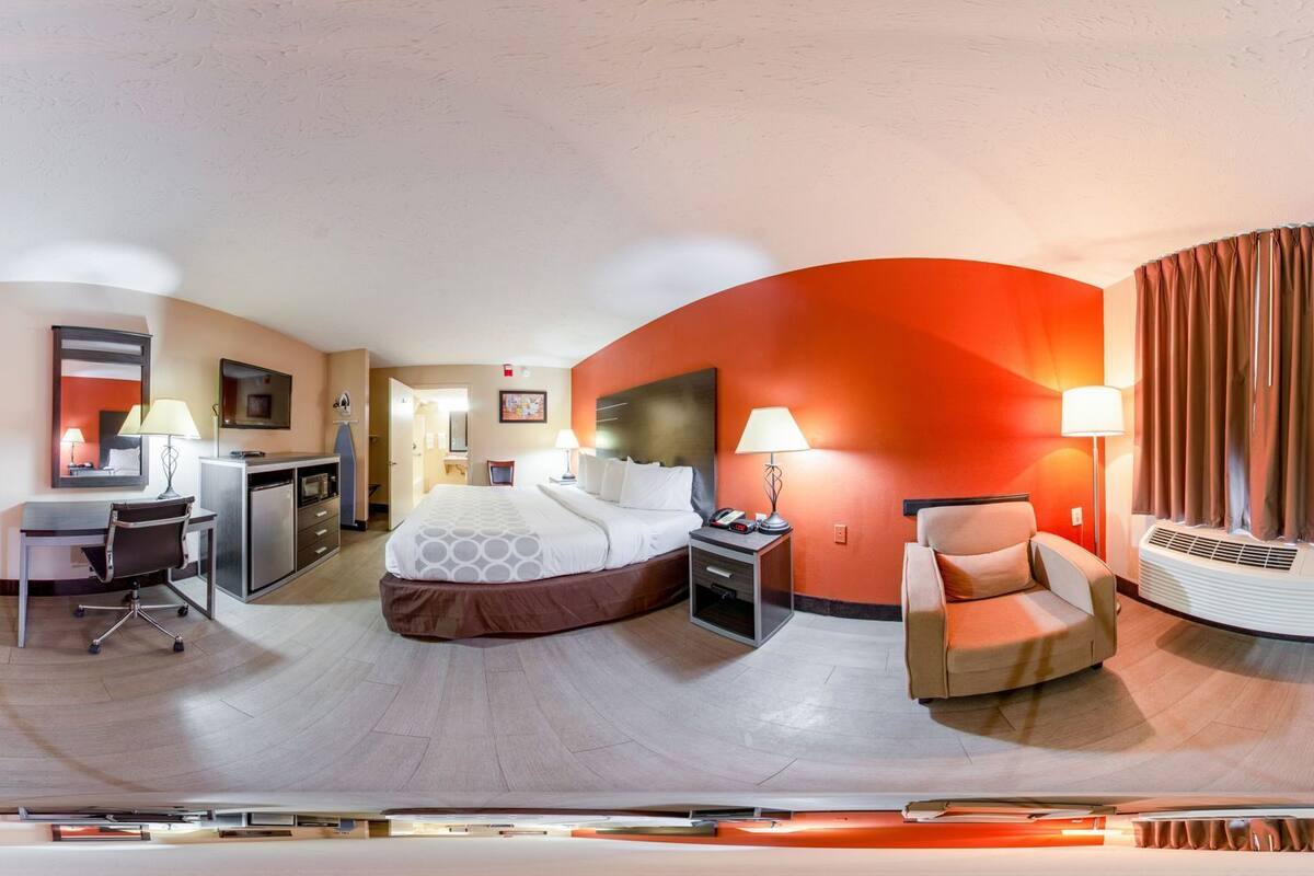 Ein Hotelzimmer mit Bett, Schreibtisch, Stuhl und einer Couch.