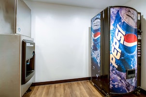 Una habitación con refrigerador, dispensador de hielo y una máquina expendedora de Pepsi.