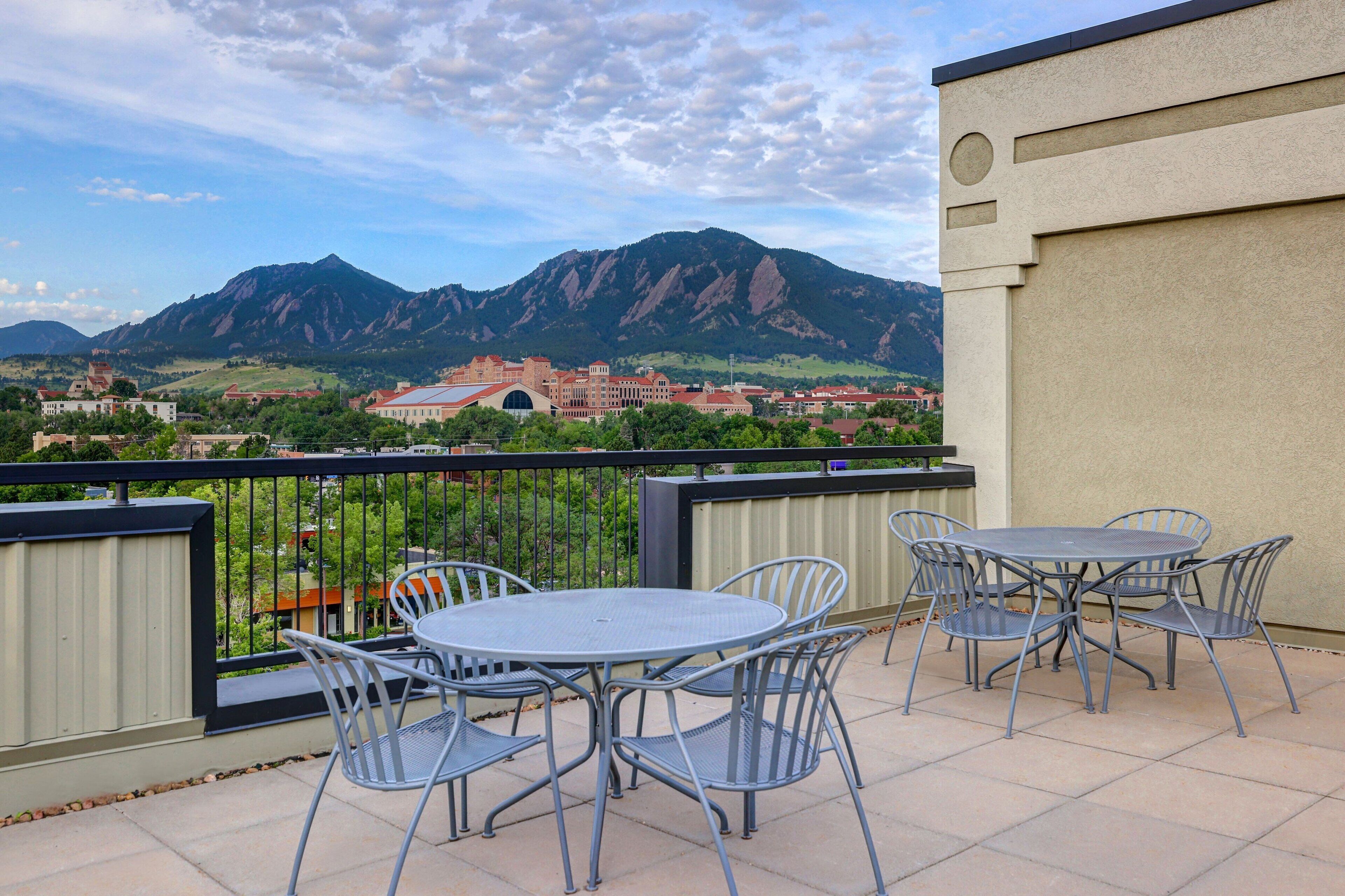 A terrace with a view of mountains and a town.