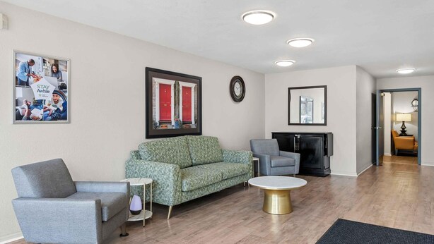 A modern living room with a sofa, armchairs, a coffee table, and a fireplace. - Extended Stay America Suites Fort Wayne North (Fort Wayne)