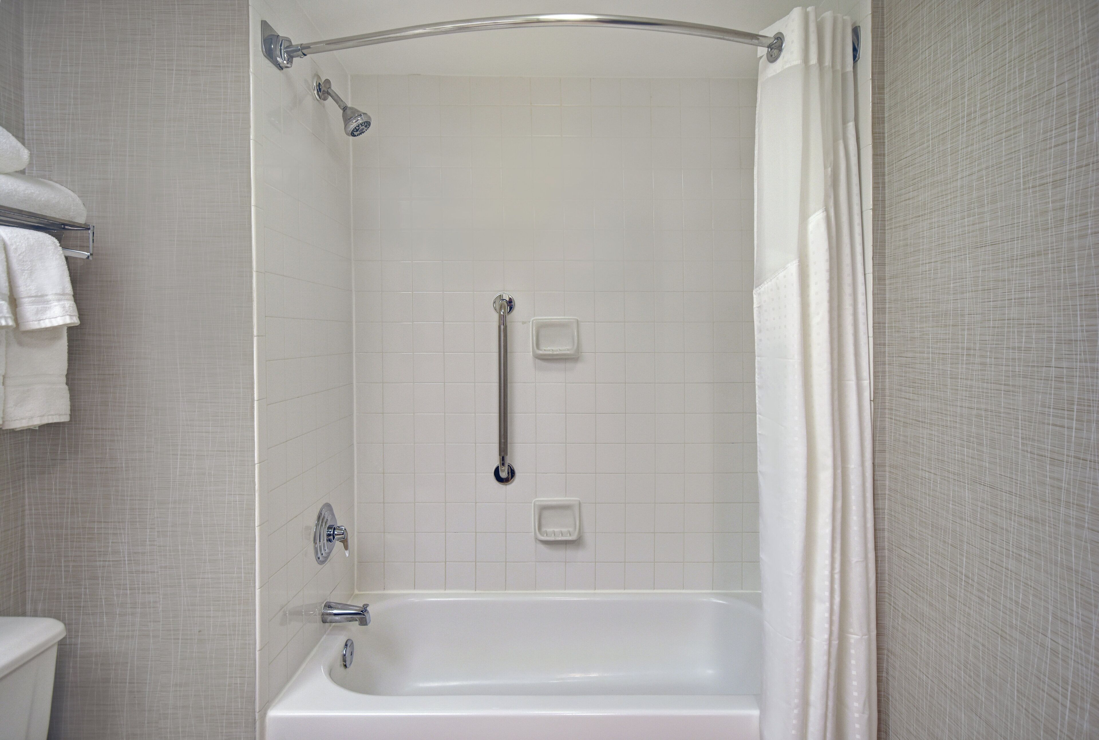 Un baño con ducha a ras de suelo, bañera y retrete.