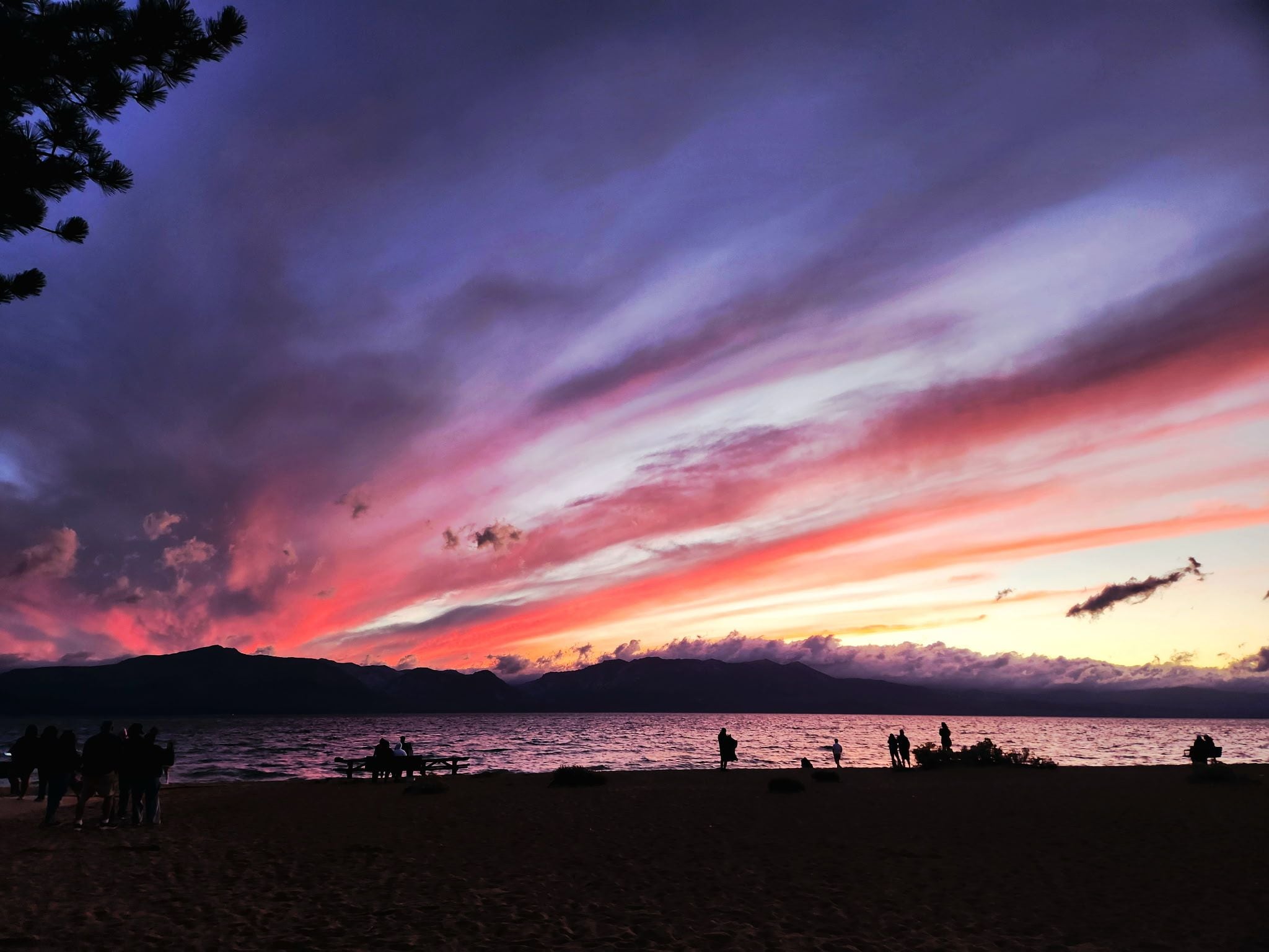 A beach with people and a sunset.