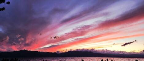 A beach with people and a sunset.