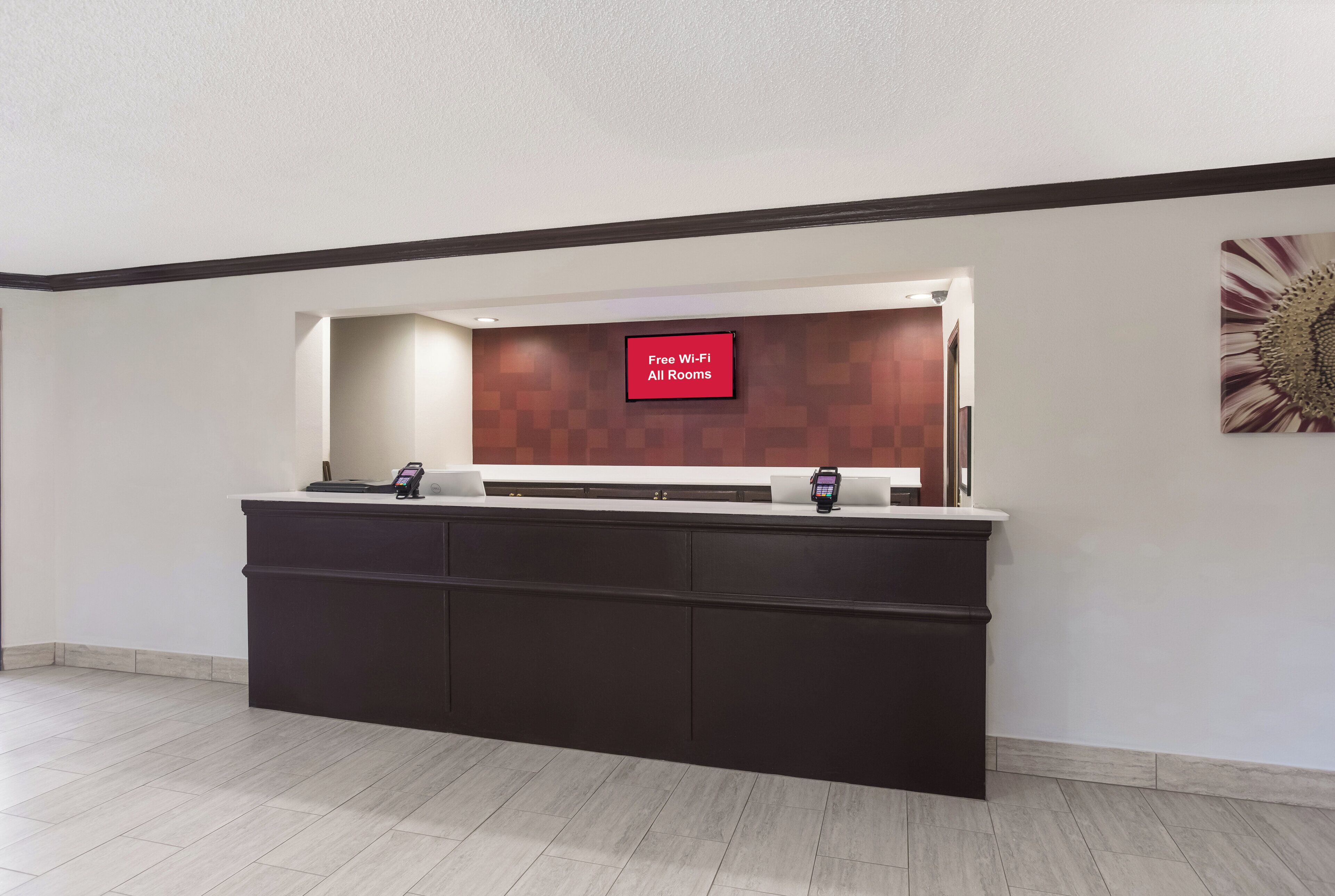 Tauleller de recepció amb una pantalla digital que mostra 'Wi-Fi gratuït a totes les habitacions' i un terminal de pagament.