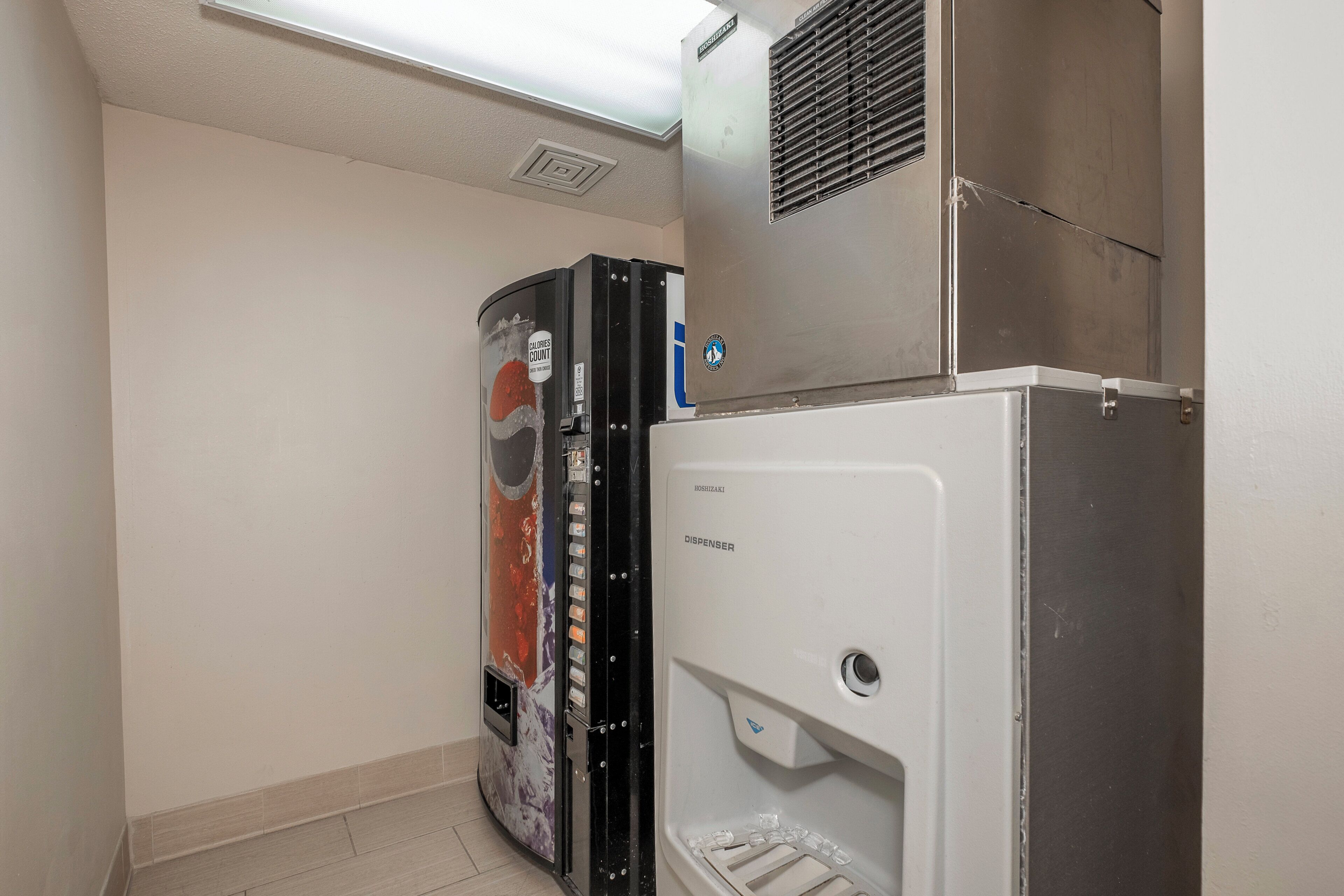 A compact kitchenette with a refrigerator, a freezer, and a built-in ice dispenser.