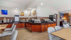 Un moderno vestíbulo de hotel con un mostrador de recepción, zona de estar y una estación de café.