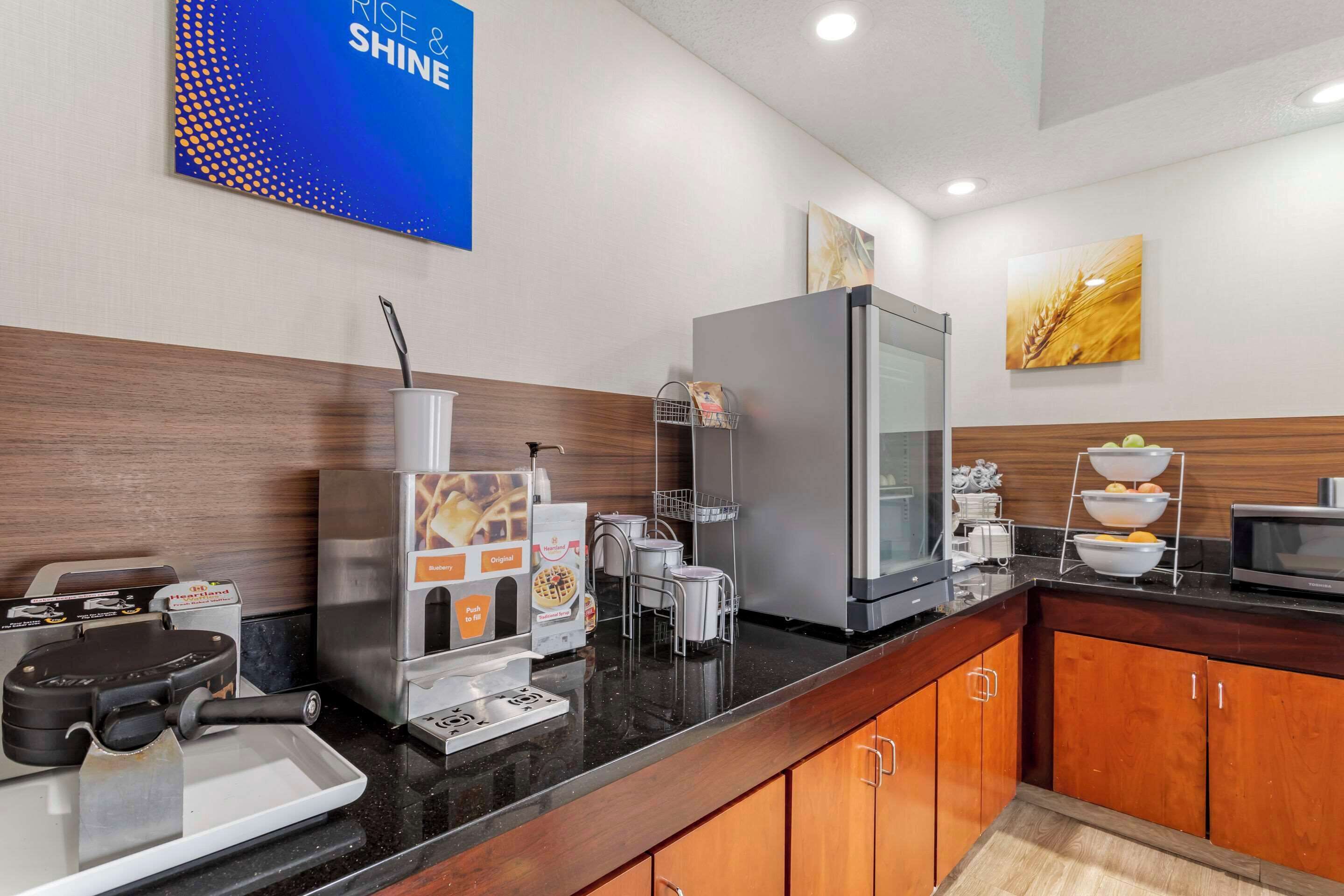 Una cucina moderna con una piastra per waffle, una macchina da caffè e un frigorifero.