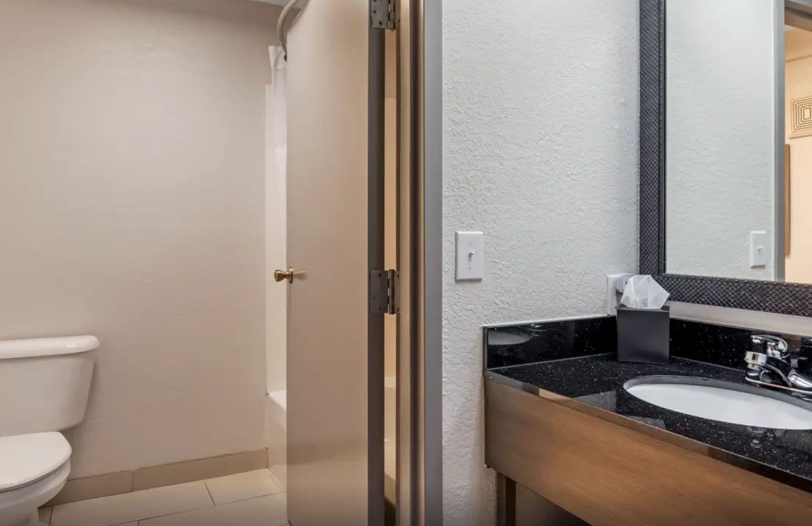 Un baño con inodoro, lavamanos y espejo.